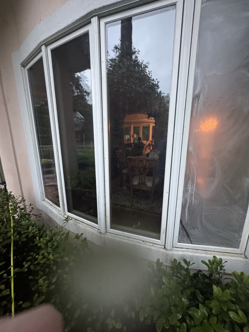 During: the same St. Simons Island bay window with cleaned panes on the left beside an uncleaned pane on the right