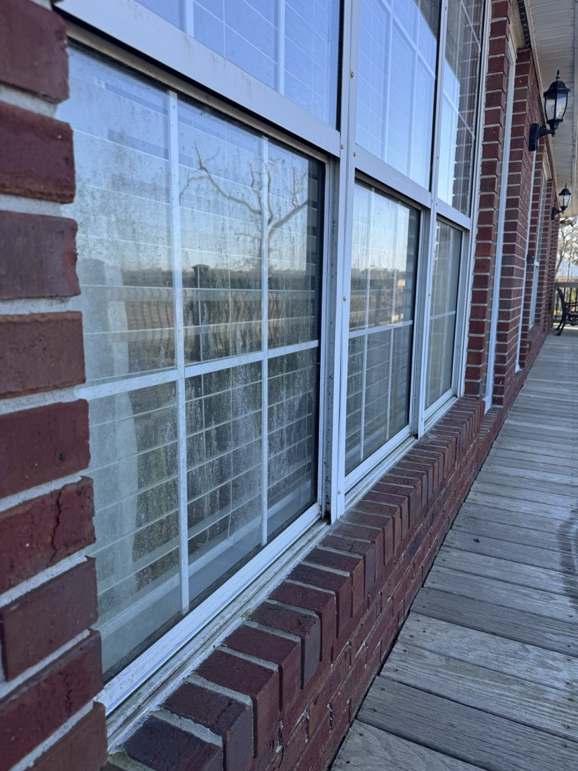 Before: dirty, streaked porch windows on a brick home in Camden County, GA
