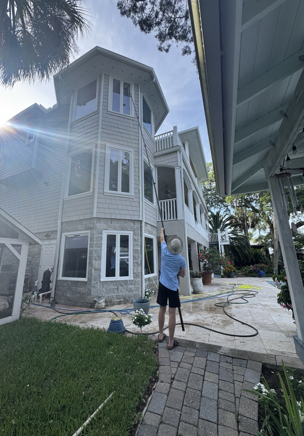 Pure Vision Window Cleaning cleaning third-story windows with a water-fed pole